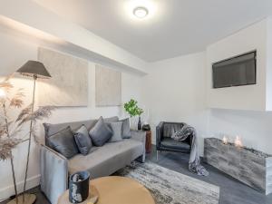 ein Wohnzimmer mit einem Sofa und einem Stuhl in der Unterkunft Justaura Retreat in Branston