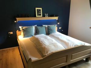 a large bed with a blue headboard in a bedroom at Ferienwohnung Morgentau am Rande der Wildnis in Sibratsgfäll