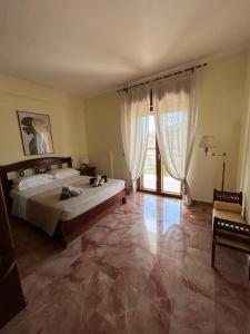 ein Schlafzimmer mit einem großen Bett und einem großen Fenster in der Unterkunft Mare qui in Gaeta