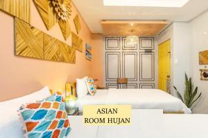 Cette chambre dispose de 2 lits et d'un panneau indiquant la chambre asiatique humaine. dans l'établissement Rain Airport Bed and Breakfast, à Manille