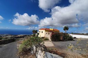 a house on the side of a road near the ocean at Sunny Island Retreat in Tejina de Isora in Guía de Isora
