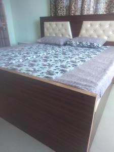 a bed in a room with a wooden bed frame at Kanta riverside Home stay in Pālampur