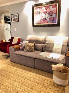 uma sala de estar com um sofá cinzento e um tapete em Apartamento sofisticado em Canela