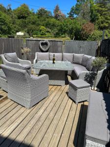 a patio with a couch and a table on a deck at Waters Reach in Abersoch