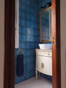 サンタンデールにあるSARDINERO CHALETの青いタイル張りのバスルーム(シンク、鏡付)