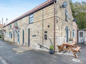 a brick building with a picnic table in front of it at Justaura Retreat in Branston