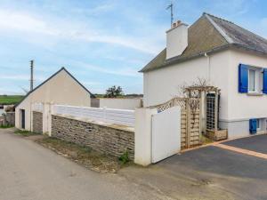 a white house with a gate and a brick wall at La Glycine in Lampaul-Plouarzel