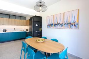 a kitchen with a wooden table and blue chairs at Dione Seaside Apartments in Hersonissos