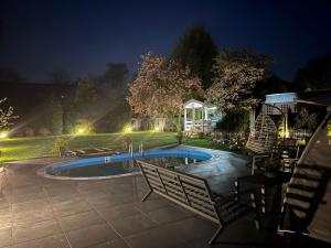 a swimming pool in a yard at night at LUXUS-RelaxDays-Apartments in Gütersloh