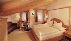 a bedroom with a large bed in a room at Garni Hotel Mirabel in Ortisei