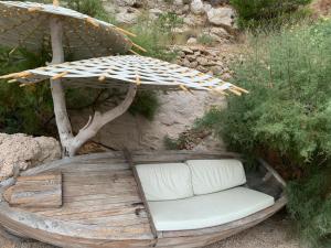 ein Holzboot mit einem Stuhl unter einem Schirm in der Unterkunft Apartments Vela Sollis in Marusici 