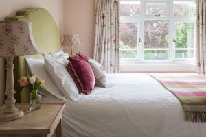 a bedroom with a white bed with pillows and a window at 2 St Elmo Lodge in Salcombe