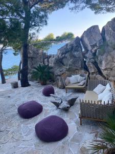 Marusici にあるApartments Vela Sollisの紫色の枕とソファ、木々が備わるパティオ
