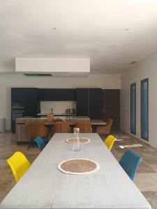 a dining room with a table and yellow chairs at Villa au calme in Montauroux