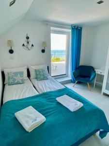 a bedroom with a bed with two towels on it at Apartament NaFali in Niechorze