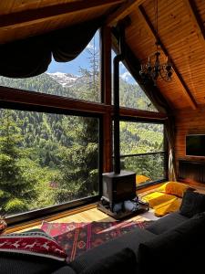 a bedroom with a large window with a tv in it at Ayder Dağ Evi in Ayder Yaylasi