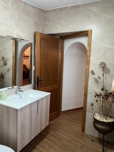 La salle de bains est pourvue d'un lavabo et d'un miroir. dans l'établissement la cueva de guadix, à Guadix