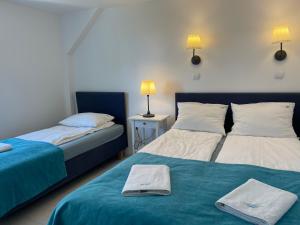 a bedroom with two beds with towels on the bed at Apartament NaFali in Niechorze