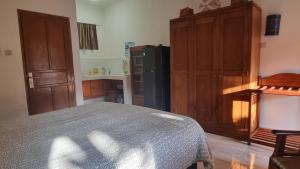 a kitchen with a bed and a black refrigerator at Catra homestay beach apartments in Candidasa