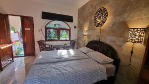 Schlafzimmer mit einem Bett und einem Tisch mit Stühlen in der Unterkunft Catra homestay beach apartments in Candidasa