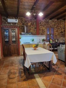 een eetkamer met een tafel en een keuken bij La Buganvilla, descanso entre olivares in Hornachuelos