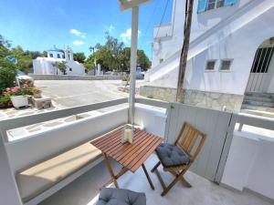 a small balcony with a wooden table and chairs at Stavros Residence in Mármara