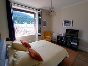 a bedroom with a bed and a large window at La petite chouette in Rochesson