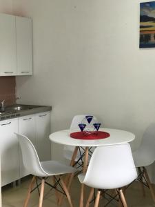 烏爾齊尼的住宿－Montebello Inn apartments，厨房配有白色的桌子和白色的椅子