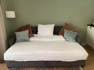 a couch with pillows on it in a room at Appartement Osso Arnhem in Arnhem