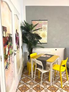 una sala da pranzo con tavolo e sedie gialle di Aria Di Casa a Roma