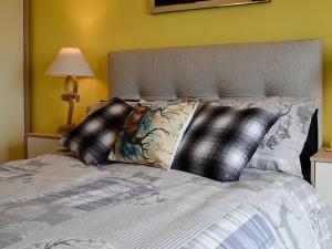 a bed with black and white pillows on it at The Outlook in Woolaston