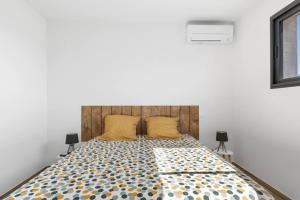 - une chambre avec un grand lit et 2 oreillers jaunes dans l'établissement Villa SUN - 600m plage - clim - 6 pers - Cap d'Agde, au Cap d'Agde