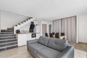 Villa SUN - 600m plage - clim - 6 pers - Cap d'Agde في كاب داغد: غرفة معيشة مع أريكة ومطبخ ودرج
