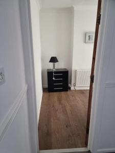 a hallway with a room with a lamp on a dresser at Margate Town House in Kent