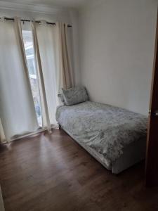 sypialnia z łóżkiem i dużym oknem w obiekcie Margate Town House w mieście Kent