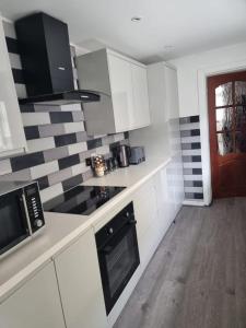 a kitchen with white cabinets and a stove top oven at Margate Town House in Kent