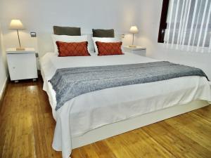 sypialnia z dużym białym łóżkiem z czerwonymi poduszkami w obiekcie Apartamento con encanto junto a la Plaza Mayor w Madrycie