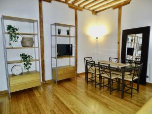 salon ze stołem, krzesłami i telewizorem w obiekcie Apartamento con encanto junto a la Plaza Mayor w Madrycie