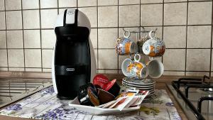 eine schwarze Kaffeemaschine auf einer Theke neben Tassen in der Unterkunft La lavanda in Controguerra