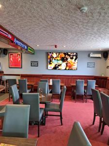 un restaurante con mesas y sillas y TV en la pared en Golden sands ingoldmells en Skegness