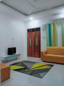 sala de estar con sofá y TV en CozyL Homestay in 3 minutes drive to Redang Jetty, en Kampong Ru Sepuloh