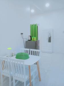 a white table and chairs with a green pillow on it at CozyL Homestay in 3 minutes drive to Redang Jetty in Kampong Ru Sepuloh