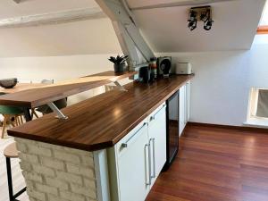 a kitchen with a wooden counter top and a table at Appartement climatisé Le Gambetta in Pont-à-Mousson