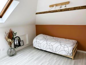- une chambre avec un lit et un vase à l'étage dans l'établissement Appartement climatisé Le Gambetta, à Pont-à-Mousson