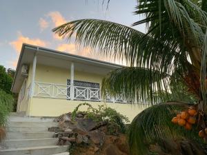 a yellow house with stairs in front of it at Naturalis - Oceanview Residences in Mahe