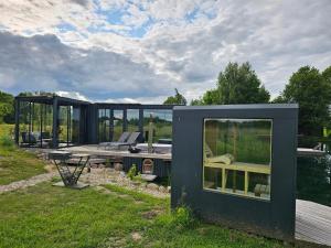 una pequeña casa negra con vistas al agua en Vaitų Riešutynė - Small shipping container house 