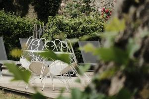 una fila di sedie bianche sedute su una terrazza di legno di La Maison Reverdi a Lamarque
