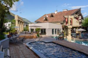 a house with a swimming pool and a building at Hotel Vier Jahreszeiten in Silandro