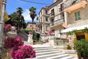a group of buildings with pink flowers and stairs at Ferruccio's House in Colonnella