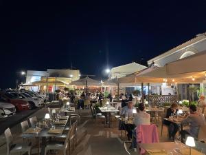 um grupo de pessoas sentadas a mesas num restaurante à noite em Il San Carlo - Suite em Avola